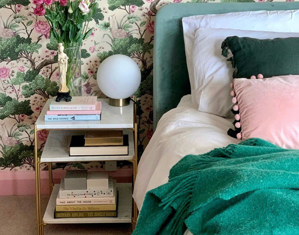 Floral bedroom with bedside table and globe lamp