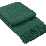 Folded green fringed throw blanket