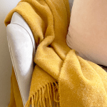 Mustard throw draped over grey armchair