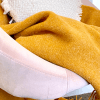 Mustard throw on pink armchair with cushion
