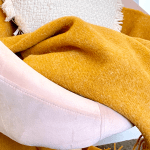 Mustard throw on pink armchair with cushion