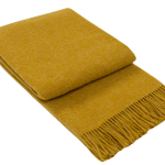 Folded mustard throw blanket with fringed edges