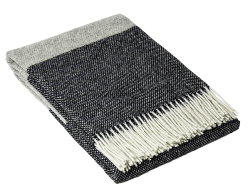 Folded grey and black fringed throw blanket