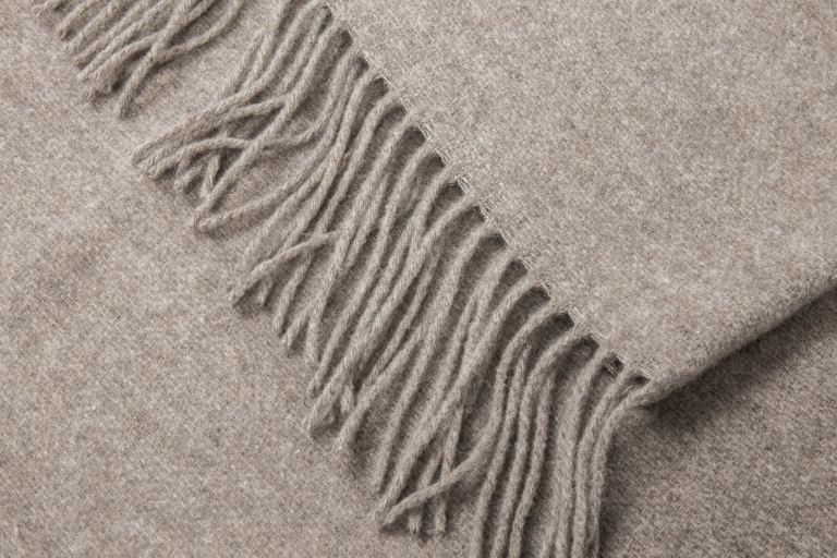 Close-up of beige wool throw with fringe