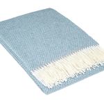 Folded light blue throw with white fringe