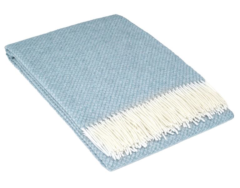 Folded light blue throw with white fringe