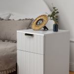 White bedside table with gold frame and vase