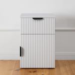 White fluted cabinet on wooden floor