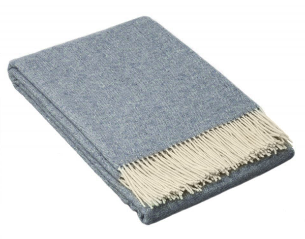 Folded blue throw blanket with cream fringe