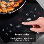 eurochef induction benchtop cooktop, 2000w, 9 heat levels, fast electric portable cooker, touch controls with slider Hand adjusting touch slider on induction cooktop