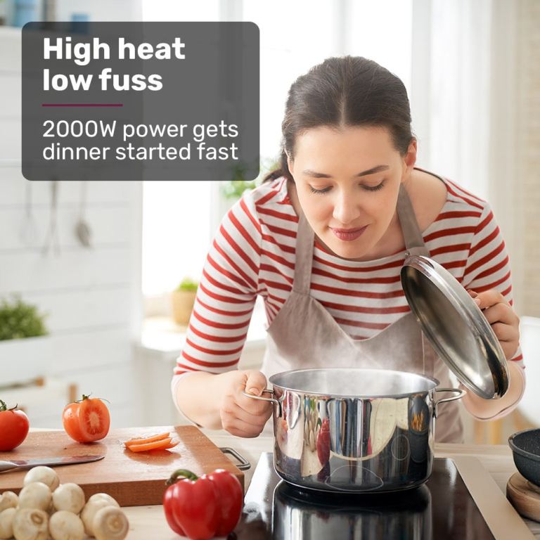 eurochef induction benchtop cooktop, 2000w, 9 heat levels, fast electric portable cooker, touch controls with slider Woman lifting lid off steaming pot on stovetop