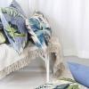 Tropical leaf cushions on white bench indoors