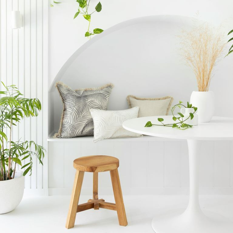 Minimalist white nook with plants and cushions