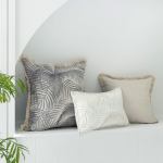 Neutral palm leaf cushions on white window seat