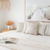 Coastal bedroom with neutral decor and beach artwork