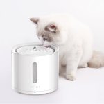 Fluffy white cat drinking from pet water fountain