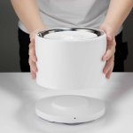 Hands holding white automatic pet water fountain