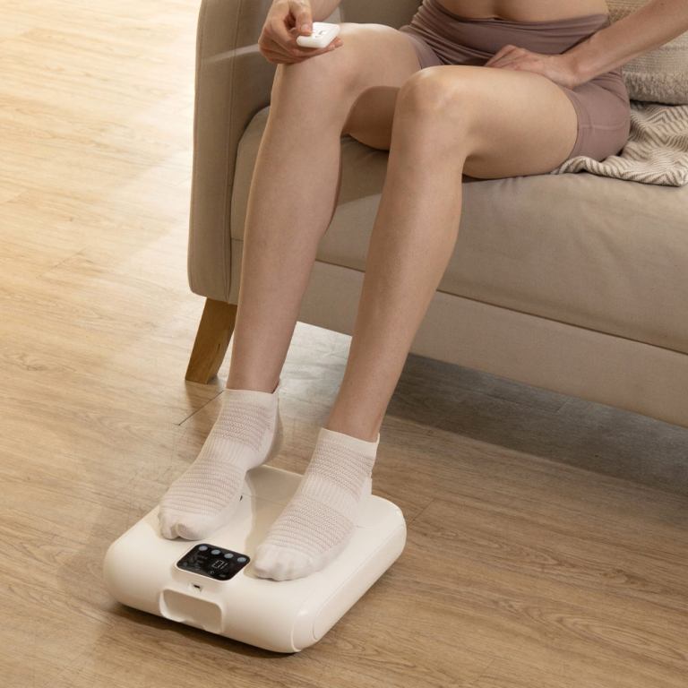 Person using electronic foot massager at home