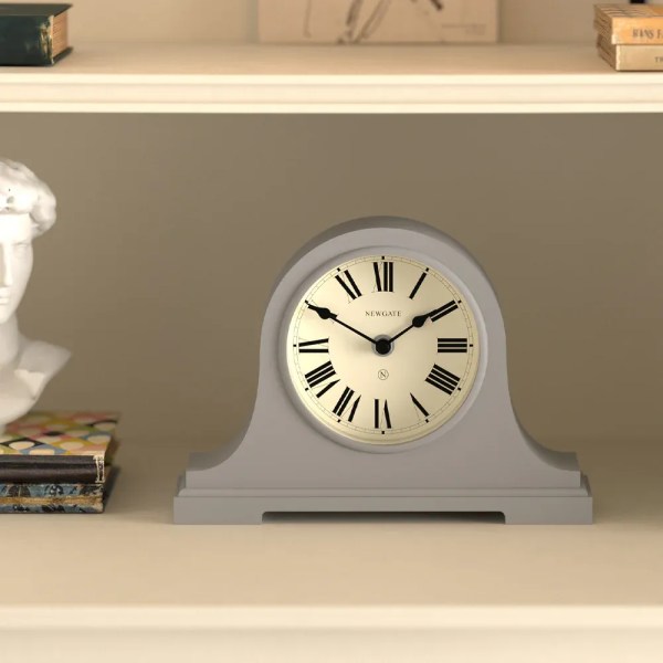 Grey mantel clock with Roman numerals on shelf