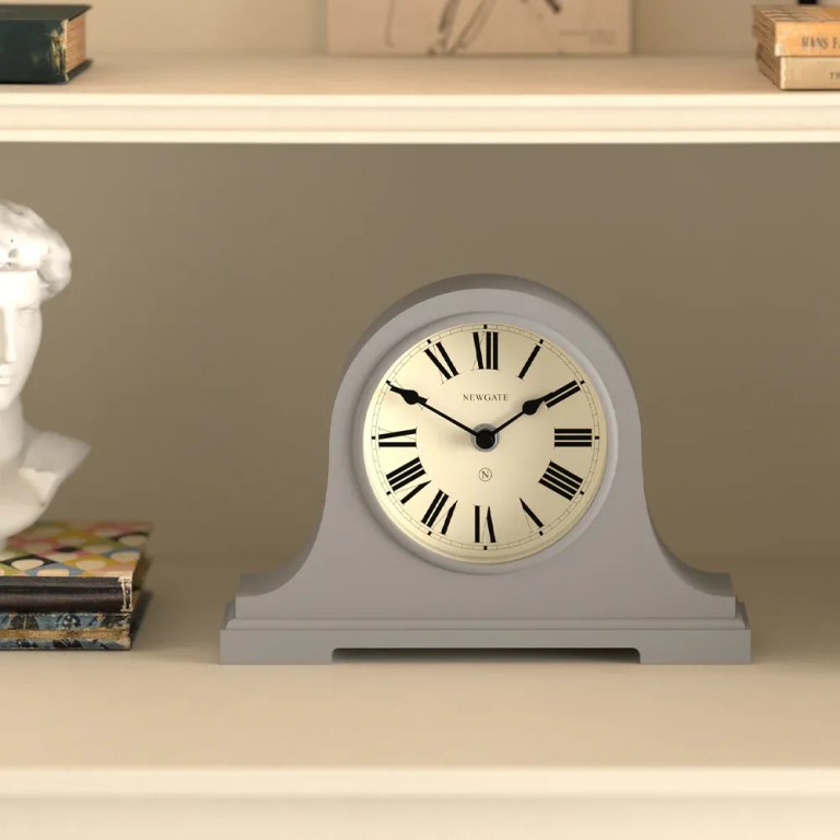 Grey mantel clock with Roman numerals on shelf