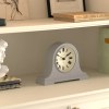 Grey mantel clock on white shelf