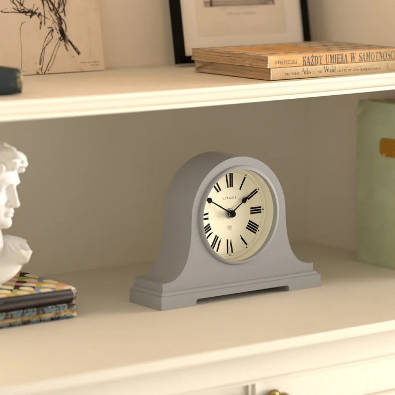 Grey mantel clock on white shelf