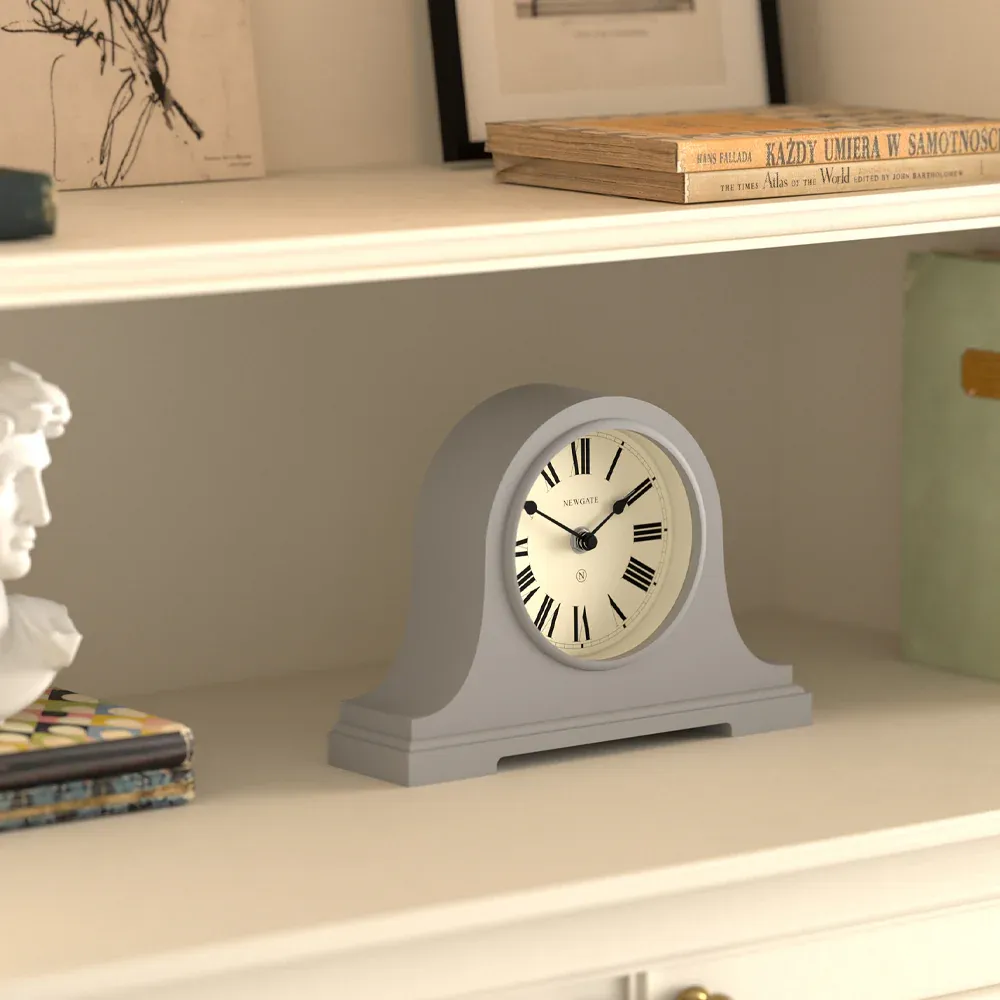 Grey mantel clock on white shelf