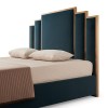 Modern upholstered bed with panelled teal headboard