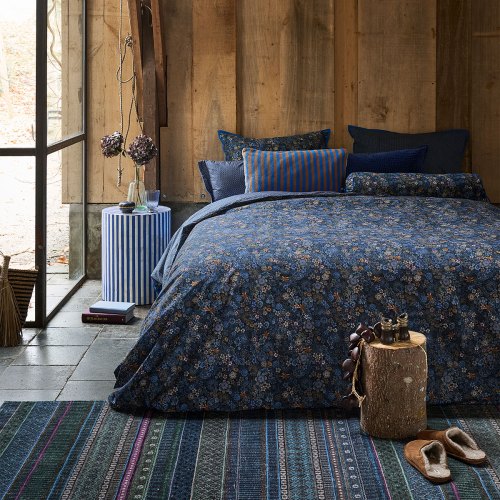 Rustic bedroom with floral bedding and timber walls