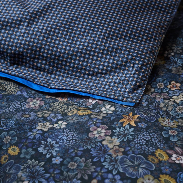 Folded patterned fabric on blue floral textile