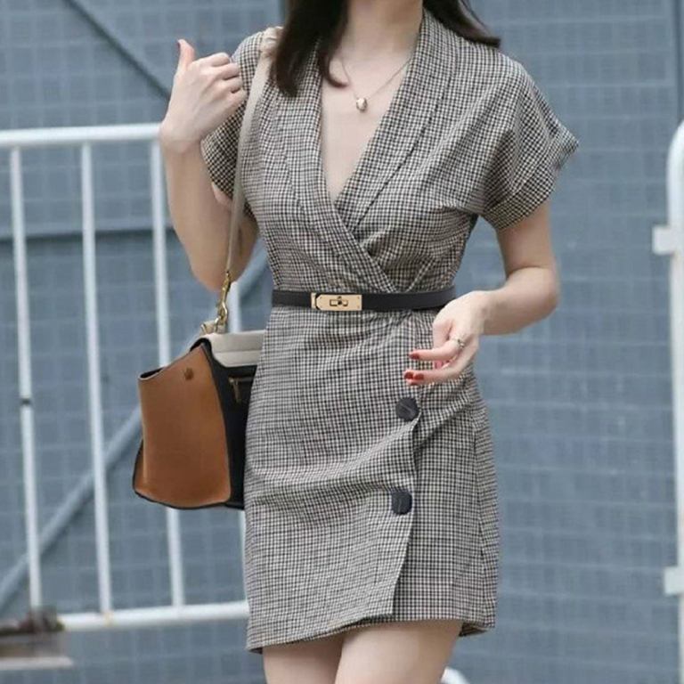 Woman in checkered wrap dress with handbag