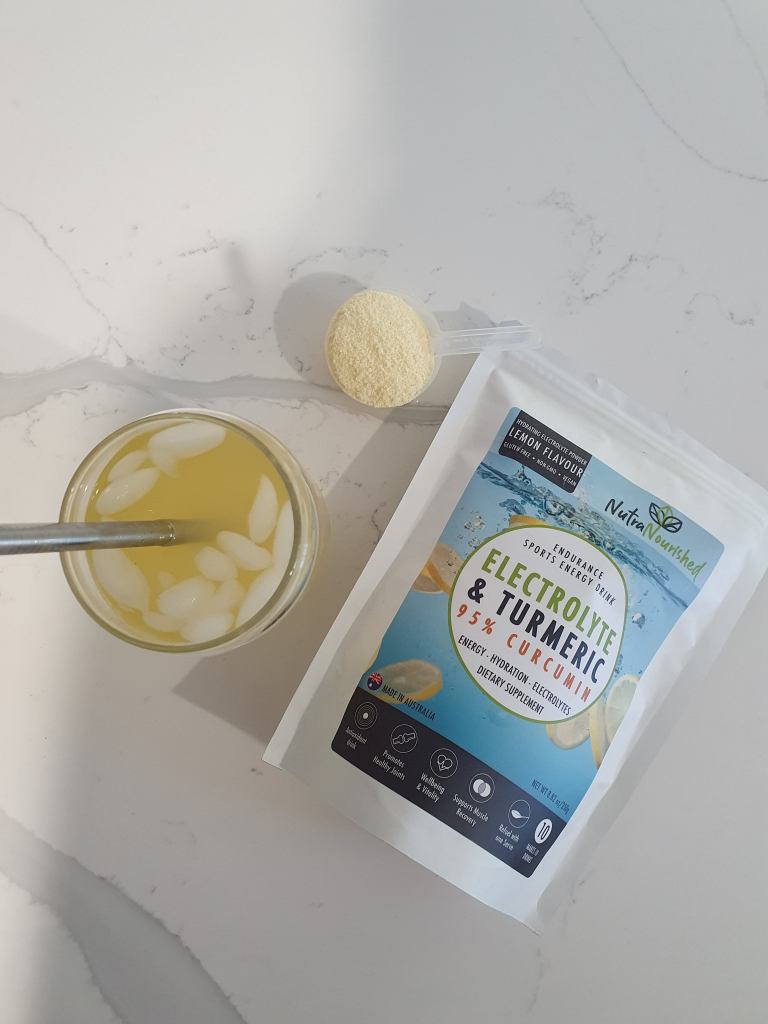 Electrolyte turmeric drink with ice and powder scoop