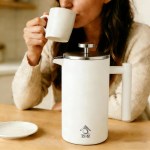 White French press and woman drinking coffee