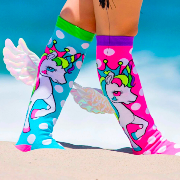 Colourful unicorn socks on sandy beach