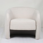 Modern cream upholstered armchair against plain wall