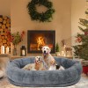 Three dogs in cosy bed by fireplace