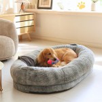 Golden dog resting on plush grey bed indoors