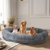 Three dogs sitting in large grey pet bed