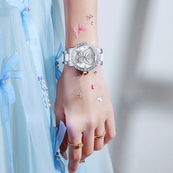 Silver butterfly watch on wrist with blue dress