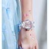 Butterfly-themed pink watch on wrist with blue dress