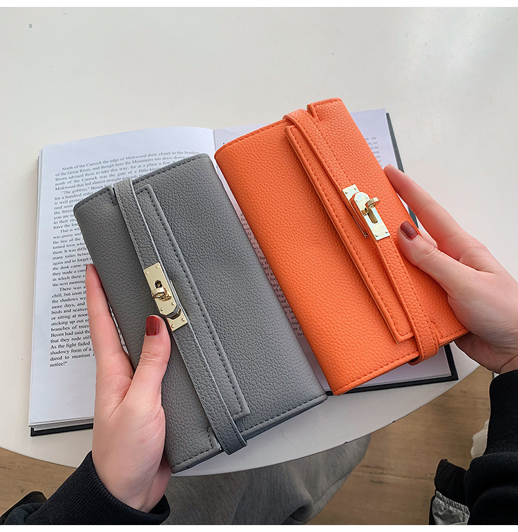 black elegant women's turn lock long wallet black pu leather clutch purse with card slots & zipper pocket Grey and orange wallets held over open book