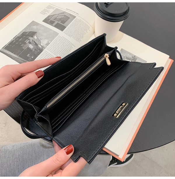 Black leather wallet opened over book and coffee