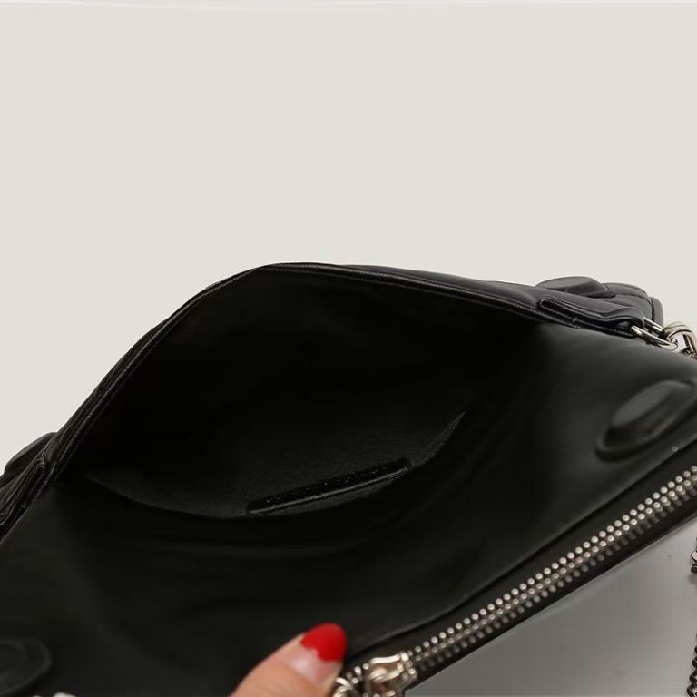 Open black leather handbag with zipper detail