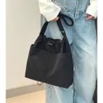 Black drawstring shoulder bag with wide-leg jeans