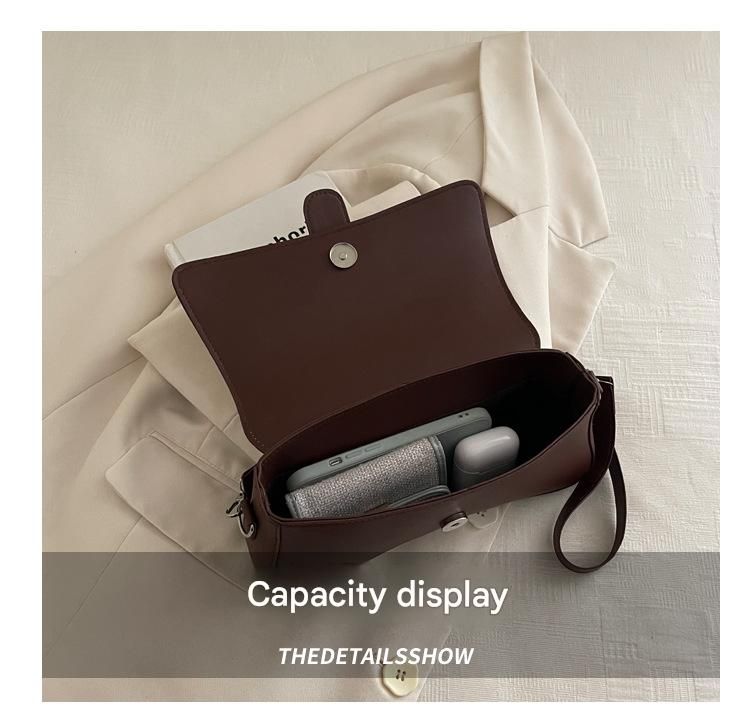 Brown leather crossbody bag showing interior capacity