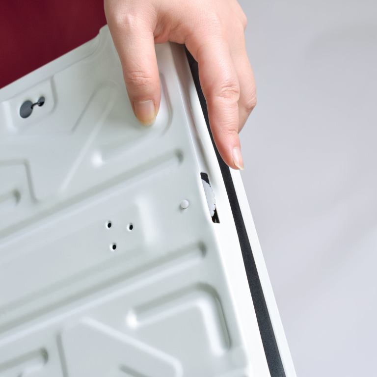 Hand checking washing machine door seal