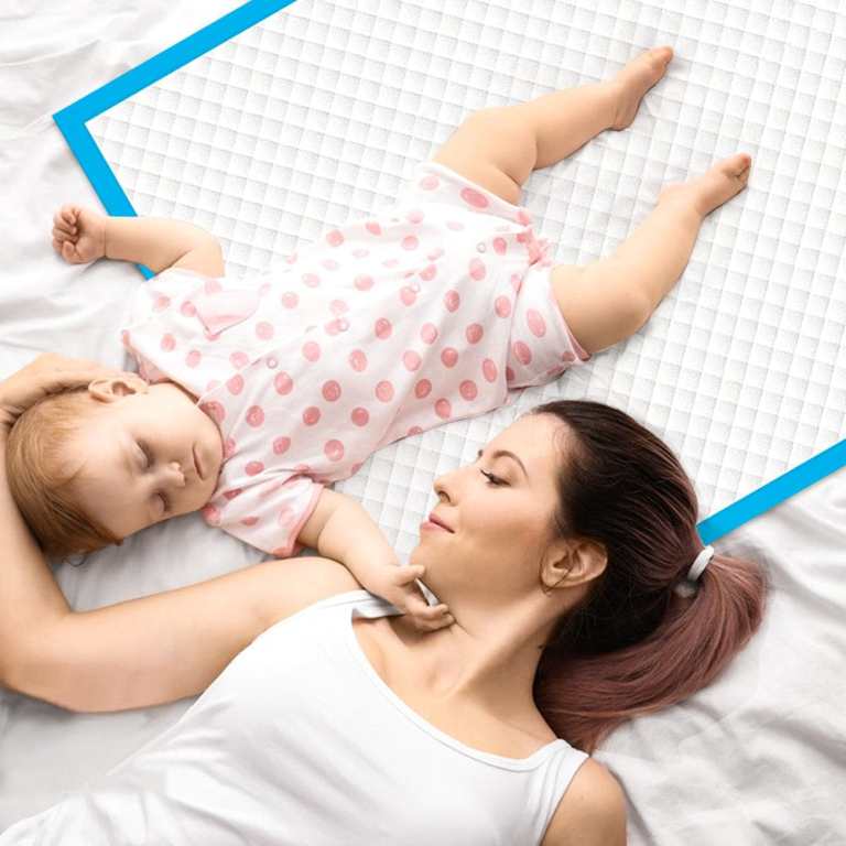 160pk adult disposable bed underpads 60 x 90cm Mother lying beside sleeping baby on bed