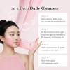 Woman applying pink facial cleanser with instructions