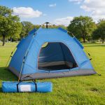 Blue camping tent set up in grassy park