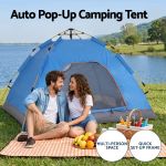 Couple beside auto pop-up camping tent by lake